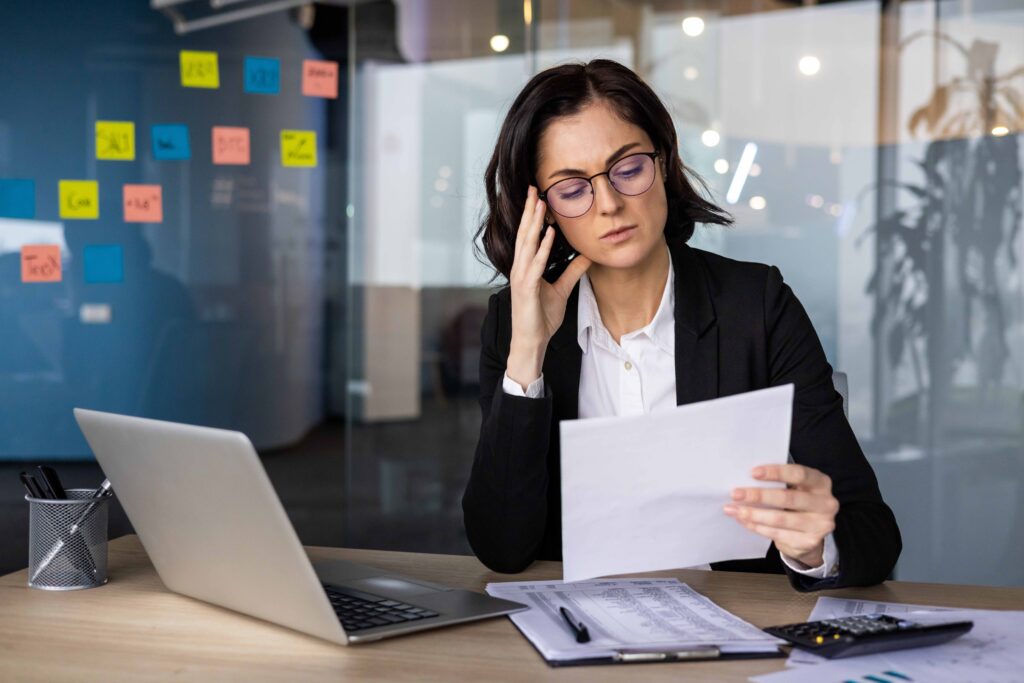 Donna in ufficio guarda con attenzione alcuni documenti che riguardano una domanda di pensione anticipata con opzione donna