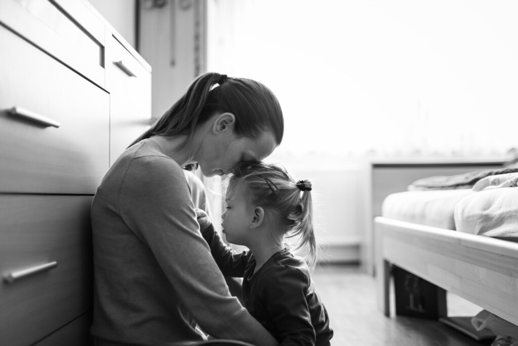 Donna che piange con figlia piccola - subentro genitore superstite Assegno Unico e Universale