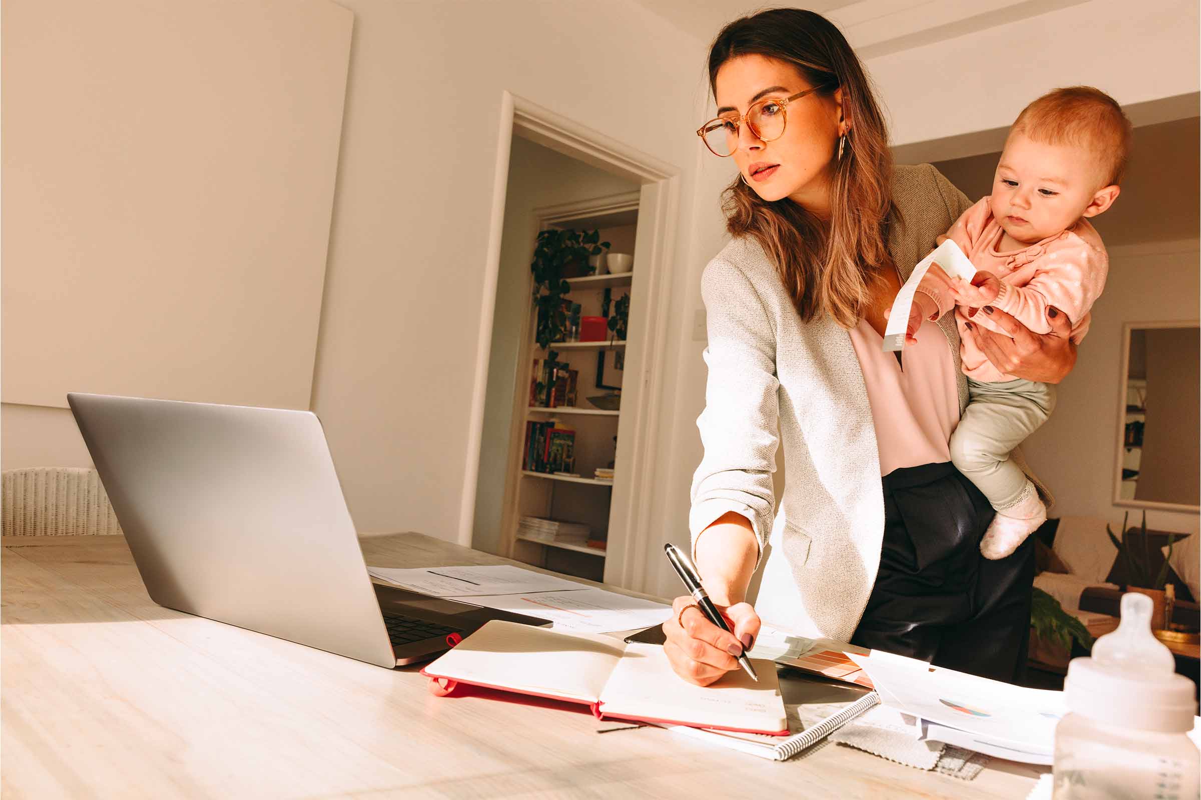 Una giovane mamma lavoratrice a casa con il figlio in mano. Per fortuna può ricevere il Bonus mamme lavoratrici per il 2026.